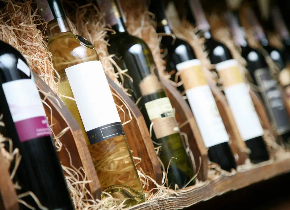 A wooden crate filled with lots of wine bottles.