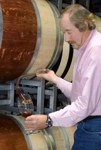 A man pouring wine into a glass.